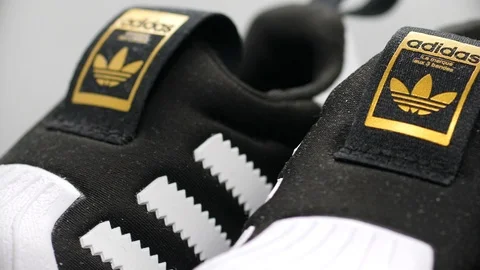 Rotating adidas sneakers for babies, studio closeup shot Stock Footage
