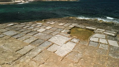 Rotating aerial footage of rectangular salt pans with sea waves on the 库存影片 281833597