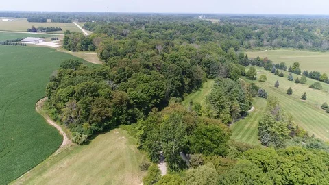 Rotating Aerial Over Golf Course Revealing Farmers Plot And Farmhouse In Dis Video stock 121175327