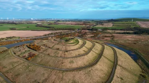 Rotating Aerial View of Grassy Mound at St. Ninian's with Distant Traffic Stock Footage 273290109