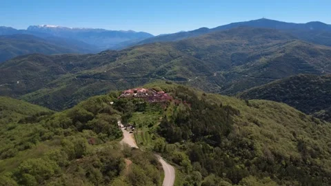 Rotating aerial view of hidden mountain village inside pristine green forest Video stock 337047289