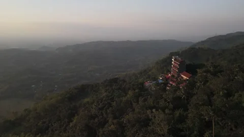 Rotating aerial view of hotel on a hill, with forest valley below. Stock Footage 293597348