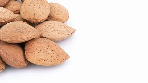 Rotating almonds isolated on white background, copy-space (loopable) Video stock 87684005