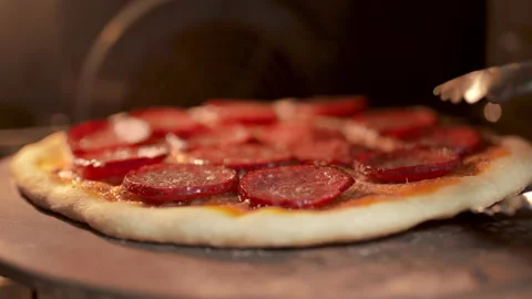 Rotating and withdrawing a pepperoni pizza from the oven in 4K Stock Footage 137431003