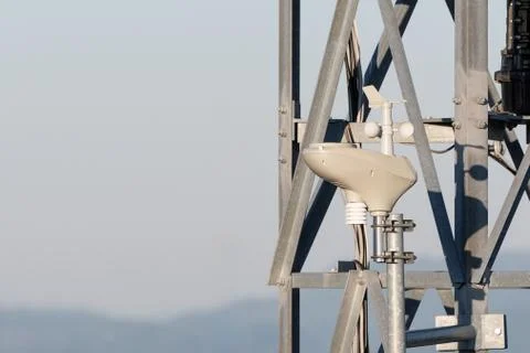 Rotating anemometer measuring wind speed mounted on steel tower Stock Photos