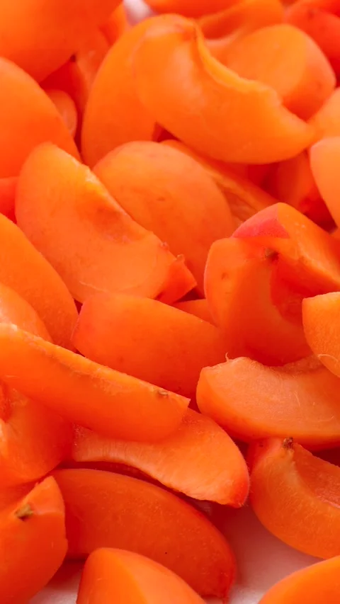 Rotating apricot quarters in circular motion on light background, closeup of Stock Footage 310338367
