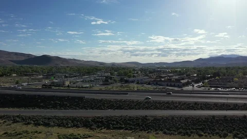 ROTATING ARIAL FOOTAGE OF MOUNTAINS AND BLUE SKY BY FREEWAY IN THE SUNSHINE Stock Footage