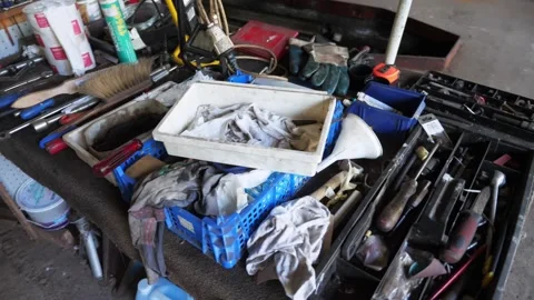 Rotating around random tools and junk on old grage work bench Stock Footage 195999383