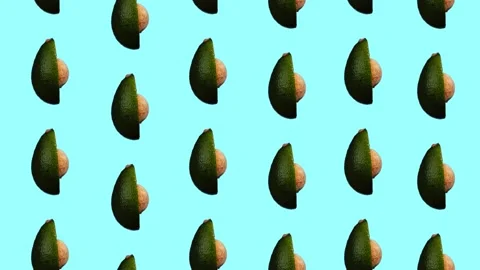Rotating avocado pattern on cyan background Stock Footage 156813296