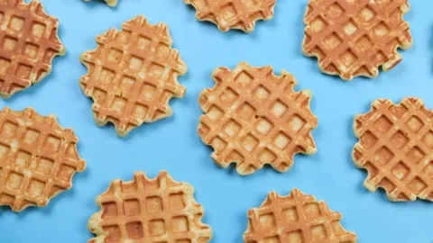 Rotating background of appetizing sweet waffles on a blue background. Summer Stock Footage 198140268