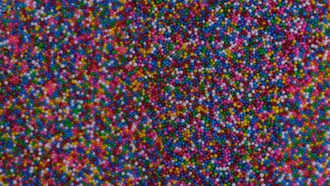 Rotating background of colorful sprinkles for sweets or beads or small balls Stock Footage 217699194