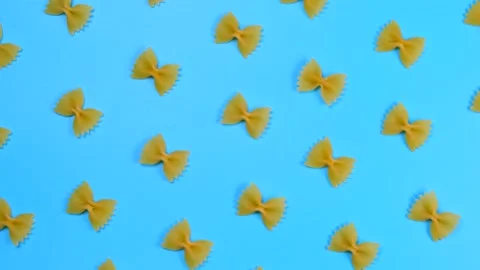 Rotating background of farfalle pasta on a blue background Stock Footage 196601620