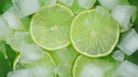 Rotating background of lime slices,mint leaves and cubes of ice ,concept of Stock Footage 197418400