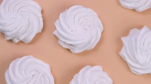 Rotating background of marshmallows or cakes, birthday cakes on a beige Stock Footage 204093234