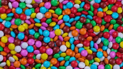 Rotating background from multi-colored sweets or chocolate drageeThe concept of Stock Footage 195889982
