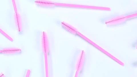 Rotating background with pink brushes for eyelashes or eyebrows on a white Stock Footage 208866510