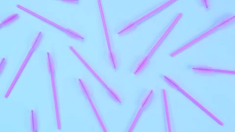 Rotating background with pink brushes for eyelashes or eyebrows on a blue Stock Footage 245489482