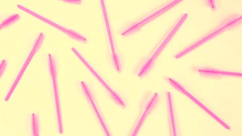 Rotating background with pink brushes for eyelashes or eyebrows on a white Stock Footage 256991927