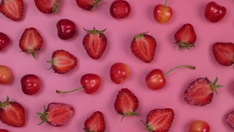 Rotating background of ripe strawberries and cherries on a pink background Stock Footage 197135841