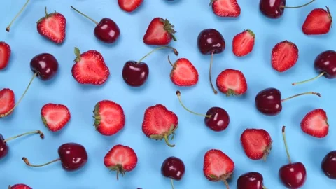 Rotating background of ripe strawberries and cherries on a blue background Stock Footage 198332946