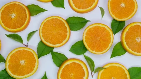 Rotating background with slides of orange and leaves on a white background Stock Footage 197484329