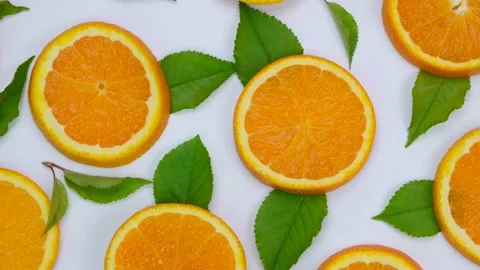 Rotating background with slides of orange and leaves on a white background Stock Footage 204964666