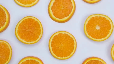 Rotating background with slides of orange on a white background, trendy summer Stock Footage 211129192