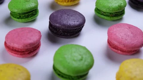 Rotating background of sweet macaroon cookies in different colors on a pink Stock Footage 229796720