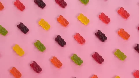 Rotating background of various jelly sweets, bears, on pink background close-up Stock Footage 246061286
