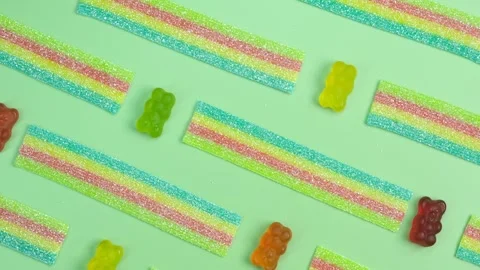 Rotating background of various jelly sweets, bears, on green background close-up Stock Footage 246173374
