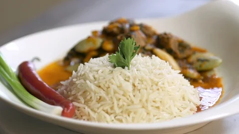 Rotating bean stew dish cooked with beef and served with rice, onion, and pepper Stock Footage 122449465