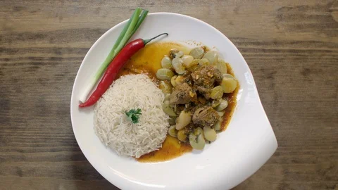 Rotating bean stew dish cooked with beef and served with rice, onion, and pepper Stock Footage 122450678