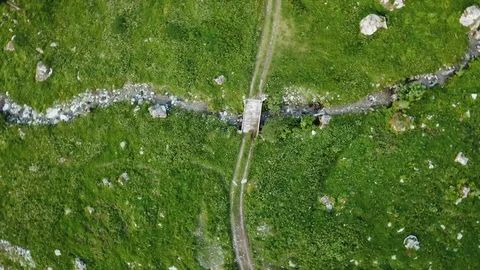 Rotating birds eye view of bridge over creek in a field Stock Footage 119824409