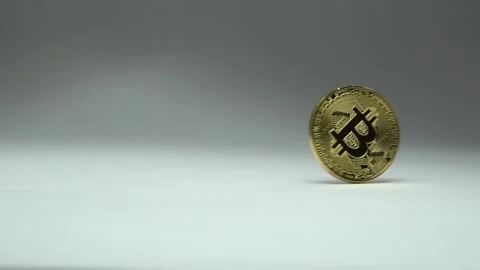 Rotating Bitcoin on a white background. Hand taking away a coin. Stock Footage 87268576
