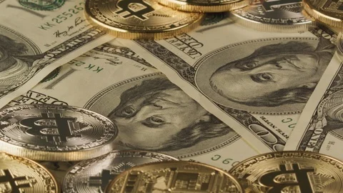 Rotating Bitcoins on top of US dollar banknotes, space for Copy. Cryptocurrency  Video stock 122339693