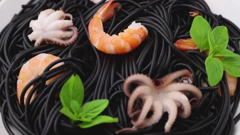 Rotating of black cuttlefish ink pasta with shrimps small octopuses and basil. Stock Footage 133725619