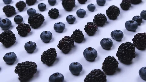 Rotating blackberries and blueberries on a white background, close-up, top view Stock Footage 212319097