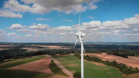 Rotating blades of wind turbine at wind farm against blue sky and fluffy clouds Stock Footage 202071897