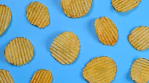 Rotating blue background with corrugated Ruffled potato chips Stock Footage 196678574