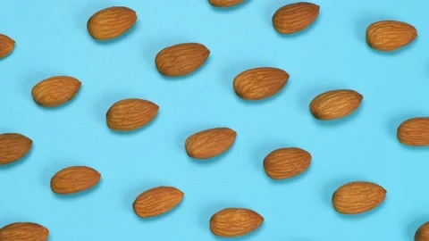 Rotating blue background with nuts almonds, close up top view Stock Footage 198402312