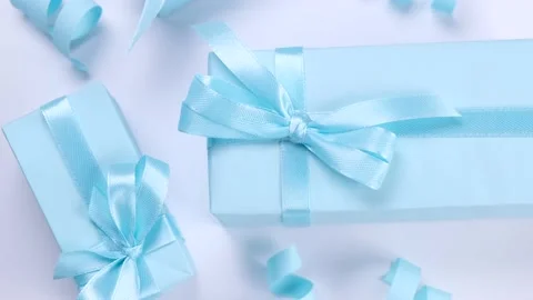 Rotating blue gift boxes with blue bows on a blue background, top view, the Stock Footage 211052923