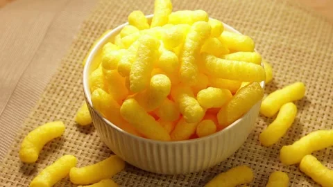 A rotating bowl filled with yellow corn sticks, resting on a rustic style b.. Stock Footage 338212402