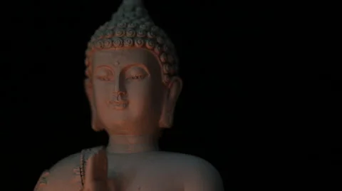 Rotating Buddha head closeup candle lit, black background (transition) Stock Footage 65489486