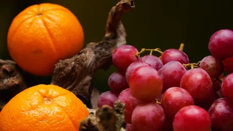 Rotating bunch of red grapes and oranges against a black background. Stock Footage 335211831