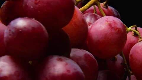 Rotating bunch of red grapes and oranges against a black background. Stock Footage 335211871