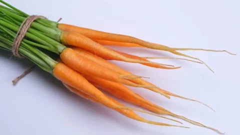 Rotating bunch of young carrots on a white background Stock Footage 198236107