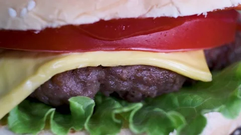 Rotating burger with beef, cheese, tomato, salad leaf in white bun, close-up. Stock Footage 139873817