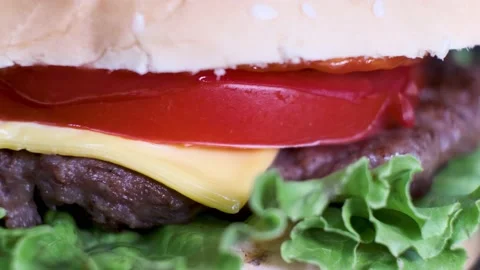 Rotating burger with beef, cheese, tomato, salad leaf in white bun, close-up. Stock Footage 139917075