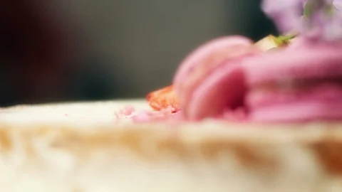 Rotating cake decoration with macaroons, strawberries and lilac, 4K slow mo Stock Footage 99320512