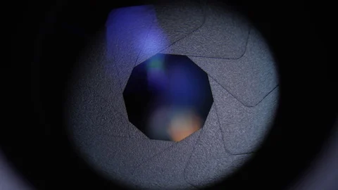 Rotating camera lens showing close up view of opening aperture iris blades Video stock 89759764